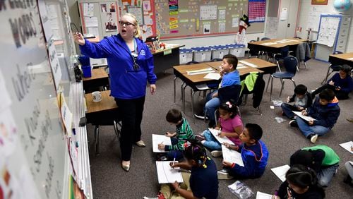 December 14, 2016, Norcross - Audrey Smith, 25, a first-year, first grade teacher at Baldwin Elementary School, draws a picture on the whiteboard for a class exercise in Norcross, Georgia. Gwinnett has approved a new teacher compensation plan that administrators hope will recruit and retain more teachers. (DAVID BARNES / DAVID.BARNES@AJC.COM)