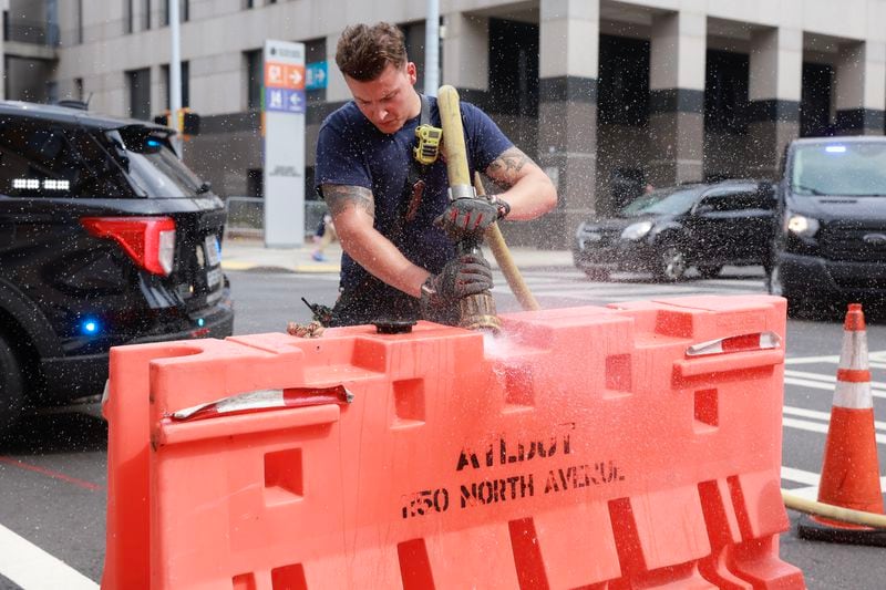 Atlanta firefighter Christofer Ernest fills road barriers with water in preparation for road closures near the Fulton County Courthouse.