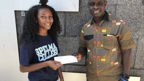 Destinee Whitaker, a recent graduate of Philadelphia’s George Washington Carver High School of Engineering and Science, presents a check to Joseph Sackor of the Liberian Medical Mission for water purification systems. (Courtesy Carver High School of Engineering and Science/TNS)