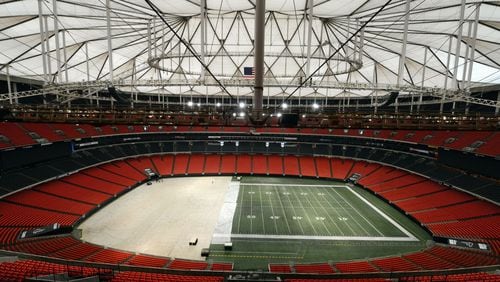 Work crews cover the playing field at the Georgia Dome with a tarp in preparation for the upcoming Monster Truck event. Mayor Kasim Reed’s argument that Atlanta needs a new stadium is being augmented by a new charge: the Georgia Dome is in need of hundreds of millions in renovations, including a new roof.
