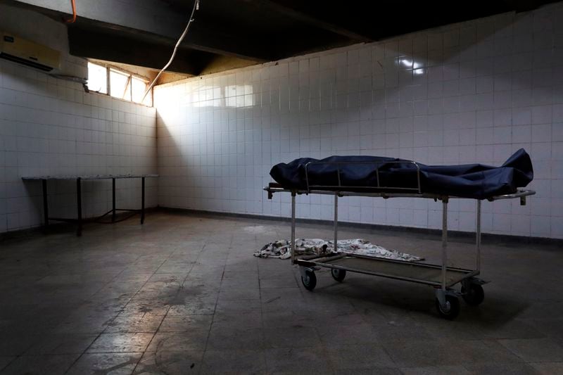 FILE - The body of a COVID-19 victim waits to be retrieved from the morgue, after she passed away the previous night at Clinicas Hospital in San Lorenzo, Paraguay, Monday, April 26, 2021. (AP Photo/Jorge Saenz, File)