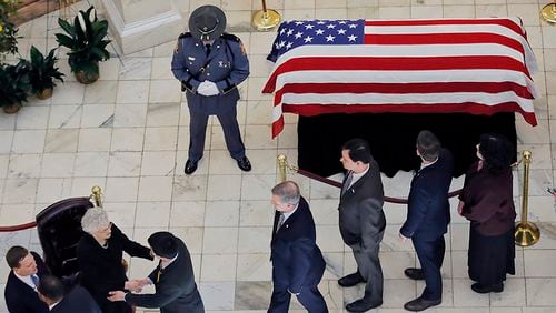 Former Gov. Zell Miller lies in state in the rotunda of the Capitol as legislators file in to pay their respects to former first lady Shirley Miller (left). He was brought to the Capitol on Tuesday after a service at Peachtree Road United Methodist Church. Legislators lined the steps of the Capitol as his casket was carried the the rotunda, where he will lie in state until Wednesday afternoon. BOB ANDRES /BANDRES@AJC.COM