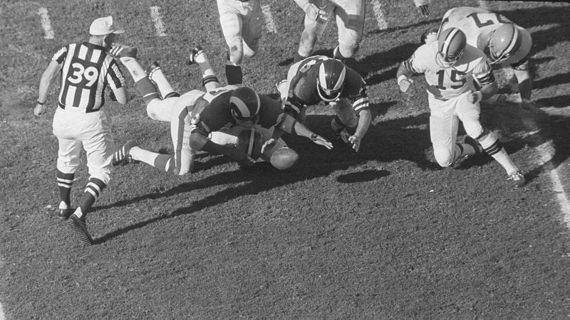 Los Angeles Rams players Irv Cross (left) and Chuck Lamson dive for the ball fumbled by Cleveland's Leroy Kelly in the third period of the NFL Pro Playoff game  Jan. 7, 1968. in Miami.  Los Angeles won 30-6.  (AP)