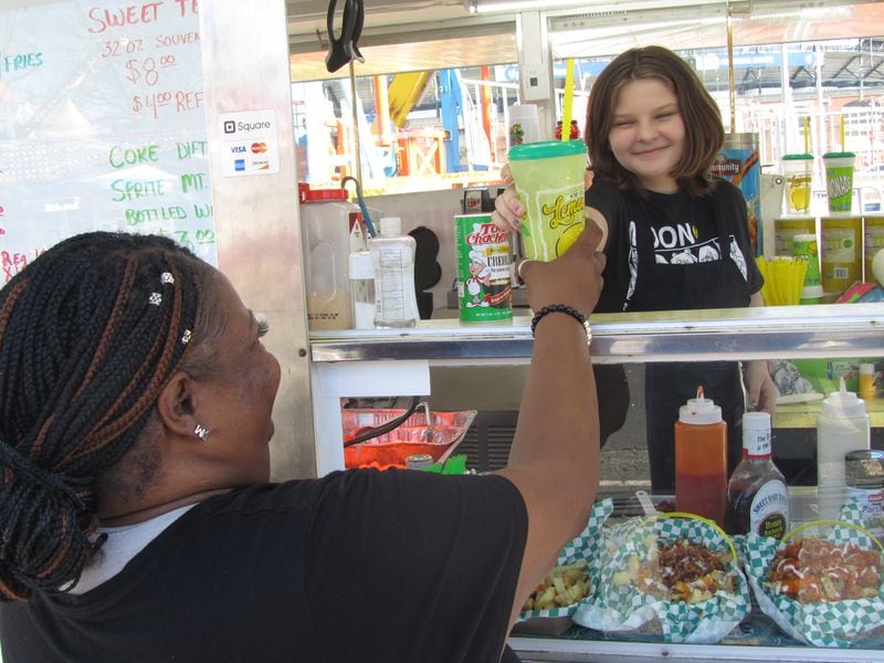 Anna Young, 12, serves up some cool lemonade at her parent’s food concession, Young’s Famous Chicken n Fries.  Photo by Grady McGill