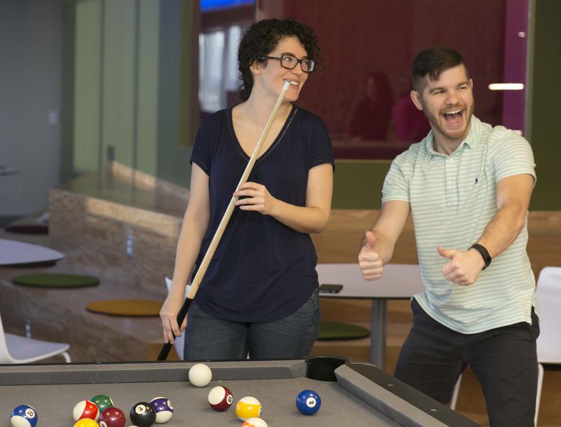 February 4, 2016-ATLANTA: Jozi Hall (left) & Andrew Hotchkiss (both cq) enjoy a game of billiards during a break at Salesforce's Atlanta office. Ping Pong, video games, a massage therapist & yoga classes help the employees enjoy their work environment. It was voted the No 1 top workplace for large companies. (Photo by Phil Skinner)