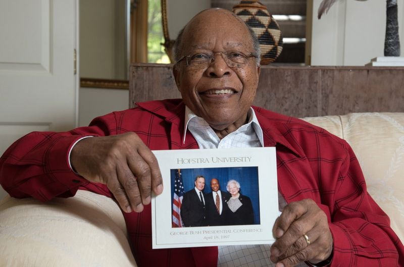 Dr. Louis Sullivan holds his photograph with the late President George H.W. Bush and the late Barbara Bush that was taken in 1997.