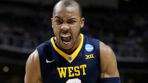 FILE  -  This March 23, 2017 file photo shows West Virginia guard Jevon Carter (2) celebrating after scoring against Gonzaga during the second half of an NCAA Tournament college basketball regional semifinal game in San Jose, Calif. College basketball's version of decision day could go a long way toward shaping how the next season will play out. West Virginia has a few pieces to replace in its Press Virginia defense, but Jevon Carter won't be one of them. (AP Photo/Tony Avelar, file)