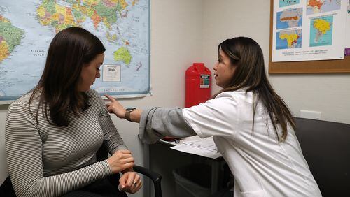 Even now, health officials recommend people get a flu shot. Shown here, Simone Groper prepares to receive a flu shot this season at a Walgreens pharmacy in San Francisco. (PHOTO by Justin Sullivan/Getty Images)