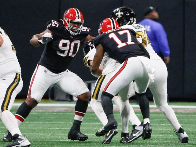 Atlanta Falcons linebacker Arnold Ebiketie (17) tackles New Orleans Saints quarterback Derek Carr during the second half of a NFL football game against the New Orleans Saints in Atlanta on Sunday, Nov. 26, 2023.   (Bob Andres for the Atlanta Journal Constitution)