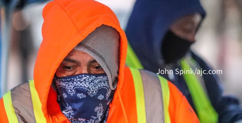Francisco Salas bundles up and wears a face covering for work at a recent morning at the Norfolk Southern construction site in downtown Atlanta. 