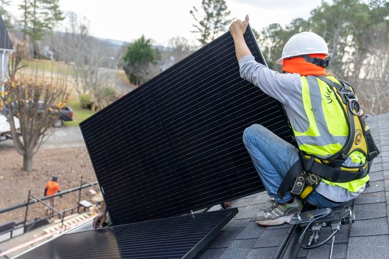 Joe McClain, an installer for Creative Solar USA, installs solar panels on a home in Ball Ground, Georgia on December 17th, 2021.