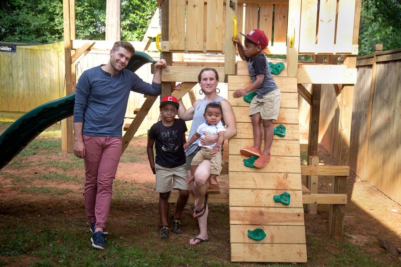Zach and Brit Eyster and their three children - Clark (red hat), Mac (Morehouse College hat) and Cyrus (baby) - pose for a photograph in the back yard of their Decatur home July 15, 2020.  STEVE SCHAEFER FOR THE ATLANTA JOURNAL-CONSTITUTION