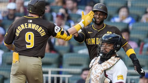 San Diego Padres' Jake Cronenworth (9) celebrates at the plate after hitting a two-run homer against the Atlanta Braves in the first inning of a baseball game, Sunday, May 19, 2024, in Atlanta. (AP Photo/Mike Stewart)
