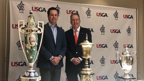 The Atlanta Athletic Club in Johns Creek was awarded three national championship sites on Tuesday. The club will host the 2025 U.S. Girls' Junior, the 2030 U.S. Amateur and the 2035 U.S. Women's Amateur. Club president Kevin Costello (right) and board member West Streib stand in front of the historic trophies.