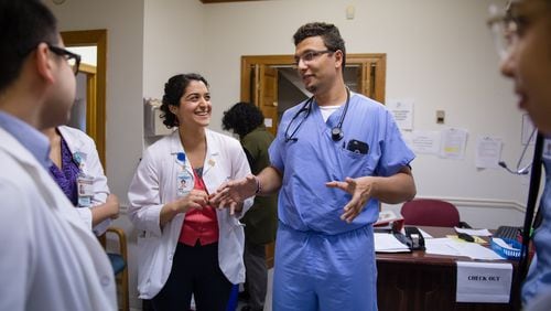 Dr. Heval Kelli (center in scrubs), a former Syrian refugee and current cardiology fellow at Emory University, speaks with medical students at the Clarkston Community Health Center in 2017. Kelli, who  has previously volunteered at the clinic, is a Kurd who still has family in northeastern Syria where the withdrawal of U.S. troops has cleared the way for the Turkish military to attack U.S. allies who had helped fight ISIS. BITA HONARVAR/SPECIAL