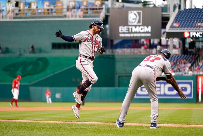 Atlanta Braves' Dansby Swanson, left, rounds the bases past third base coach Ron Washington after hitting a two-run home run in the first inning of a baseball game against the Washington Nationals, Thursday, July 14, 2022, in Washington. (AP Photo/Patrick Semansky)