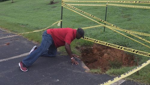 Henry County commissioner Bruce Holmes examines a large sinkhole at Cochran Park.