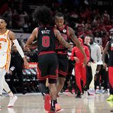 Chicago Bulls guard Coby White (0) celebrates with guard Ayo Dosunmu after a Bulls basket during the second half of the team's NBA basketball play-in tournament game against the Atlanta Hawks in Chicago, Wednesday, April 17, 2024. The Bulls won 131-116. (AP Photo/Nam Y. Huh)