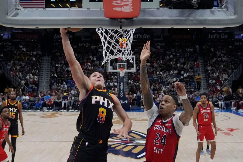 Phoenix Suns guard Grayson Allen (8) goes to the basket against New Orleans Pelicans guard Jordan Hawkins (24) in the first half of an NBA basketball game in New Orleans, Monday, April 1, 2024. (AP Photo/Gerald Herbert)