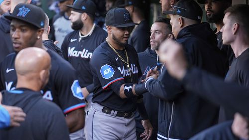 Miami Marlins' Luis Arraez, center, shakes hands with teammates in the dugout after being traded to the San Diego Padres before the team's baseball game against the Oakland Athletics, Friday, May 3, 2024, in Oakland, Calif. (AP Photo/Godofredo A. Vásquez)