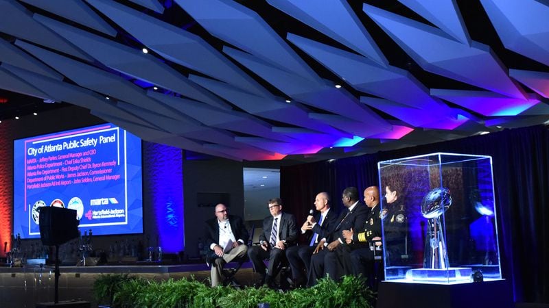 Panelists discuss Super Bowl preparations on Friday with the Vince Lombardi Trophy, awarded each year to the Super Bowl-winning team,  nearby.