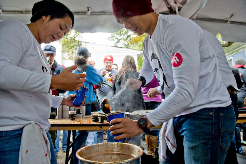 Beth Yeckley (left) and Dale Kim scoop out cups of chili during the 12th annual Cabbagetown Chomp & Stomp in Atlanta on Saturday, November 1, 2014. The one day festival attracts tens of thousands of people to taste chili, look at art, listen to music and celebrate the historic neighborhood. JONATHAN PHILLIPS / SPECIAL