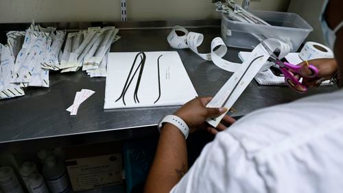 A clinic employee packages dilators for a final sanitization at Women’s Feminist Health Center in Atlanta on Wednesday, August 17, 2022. (Natrice Miller/natrice.miller@ajc.com)