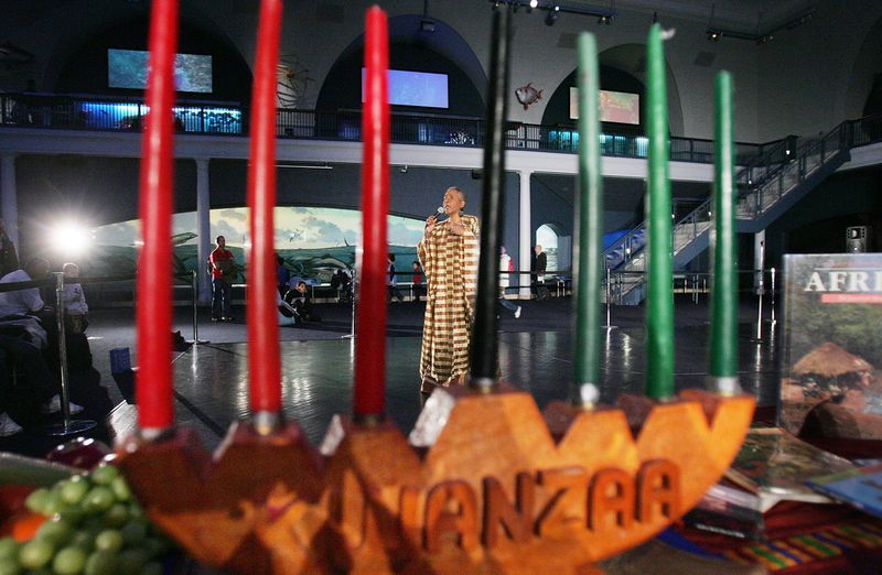 NEW YORK - DECEMBER 22:  Camille Yarborough sings African music behind a traditional "kinara" candelabra during a preview of the 'Kwanzaa 2004: We Are Family' festival at the American Museum of Natural History December 22, 2004 in New York City.