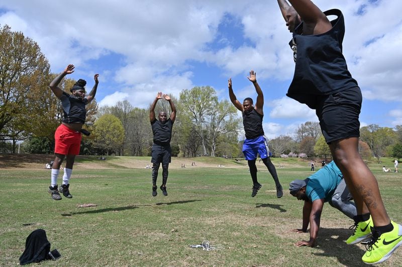 Que Smith (left) leads an exercise as people enjoy spring weather at Piedmont Park on Saturday, March 21, 2020. The park’s playground was closed but people found ways to enjoy the outdoors. HYOSUB SHIN / HYOSUB.SHIN@AJC.COM
