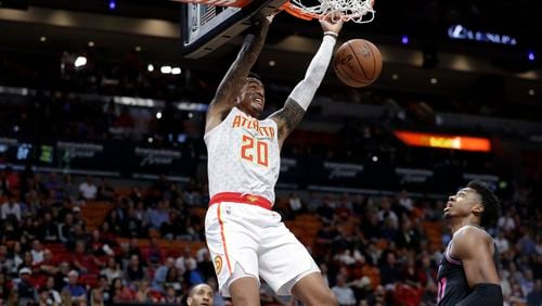 Hawks forward John Collins (20) dunks over Miami Heat center Hassan Whiteside during the first half of an NBA basketball game, Tuesday, Nov. 27, 2018, in Miami. (AP Photo/Lynne Sladky)