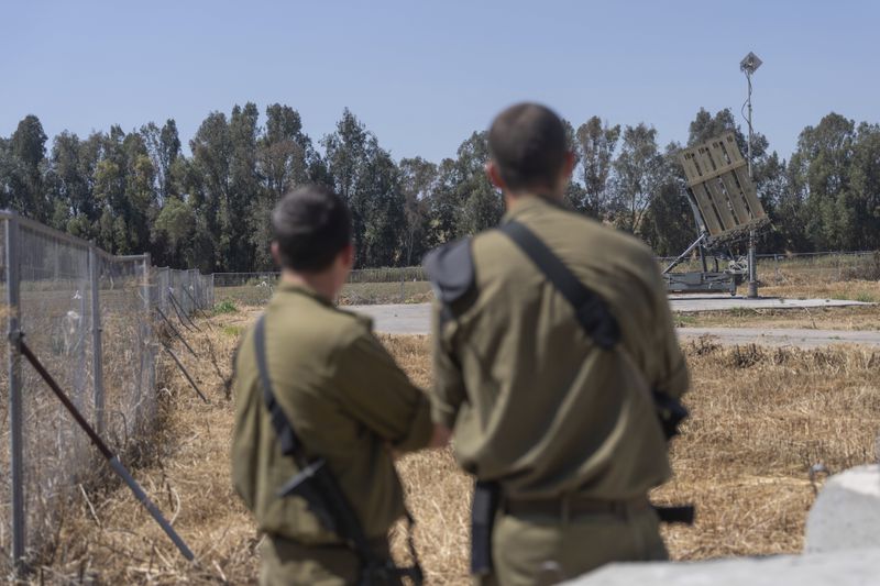 Israeli soldiers stand near the Iron Dome, a new anti-rocket system, near the southern Israeli city of Sderot, Israel, Wednesday, April 17, 2024. (AP Photo/Ohad Zwigenberg)