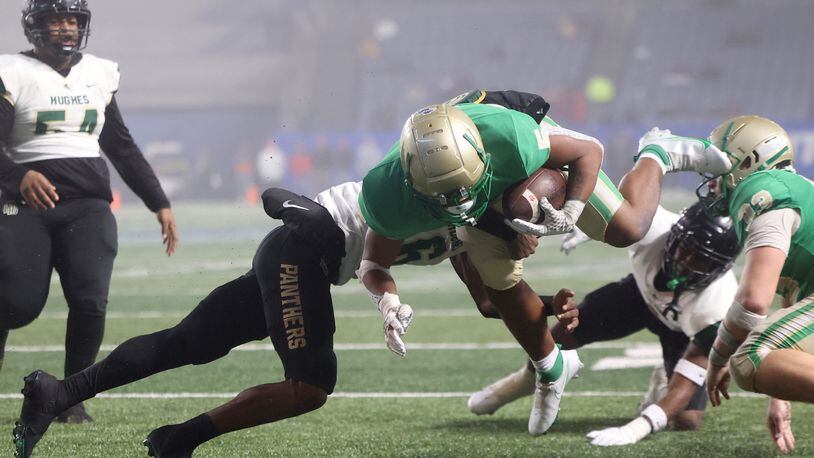 December 10, 2021 - Atlanta, Ga: Buford running back CJ Clinkscales (5) scores a touchdown against Langston Hughes defensive back Rodney Shelley (6) during the first half of the Class 6A state title football game at Georgia State Center Parc Stadium Friday, December 10, 2021, Atlanta. JASON GETZ FOR THE ATLANTA JOURNAL-CONSTITUTION