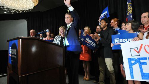 May 20, 2014 Atlanta - David Perdue waves to his supporters as his wife Bonnie stands next to him at his election night party at Doubletree Hotel in Buckhead on Tuesday, May 20, 2014. HYOSUB SHIN / HSHIN@AJC.COM David Perdue greets supporters in Buckhead (AJC/Hyosub Shin)