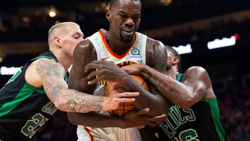 Hawks center Dewayne Dedmon tries to keep the ball from Boston Celtics guard Marcus Smart, right, and forward Daniel Theis, left. (AP Photo/John Amis)