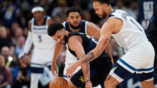 Denver Nuggets guard Jamal Murray, front left, loses control of the ball as Minnesota Timberwolves forward Kyle Anderson, front right, and center Karl-Anthony Towns defend in the second half of Game 2 of an NBA basketball second-round playoff series, Monday, May 6, 2024, in Denver. (AP Photo/David Zalubowski)