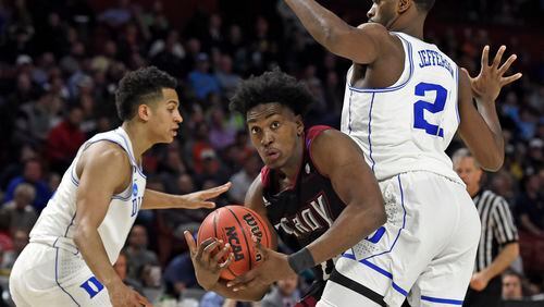 Troy's Jordon Varnado, center, drives around Duke's Chase Jeter, right, and Frank Jackson, left, during the second half in a first-round game of the NCAA men's college basketball tournament in Greenville, S.C., Friday, March 17, 2017. (AP Photo/Rainier Ehrhardt)