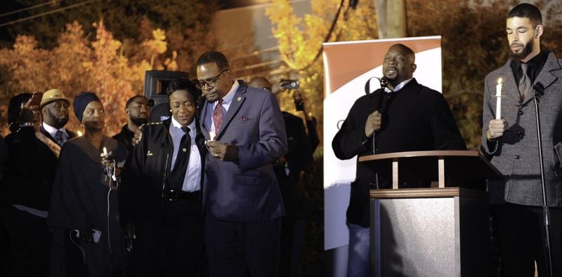 The Rev. Markel Hutchins speaks during a vigil for Alexis Crawford on Nov. 10. Clark Atlanta University Student Government Association President Levon Campbell Jr. is standing to the right of Hutchins. Clark Atlanta President George T. French Jr. is to the left of Hutchins, with his arm around the university’s police chief, Debra A. Williams. 