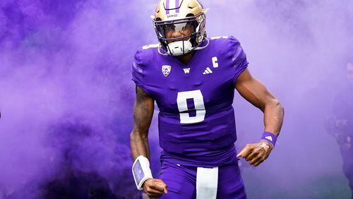 Washington quarterback Michael Penix Jr. runs out to the field through purple smoke before an NCAA college football game against Oregon, Saturday, Oct. 14, 2023, in Seattle. (AP Photo/Lindsey Wasson)