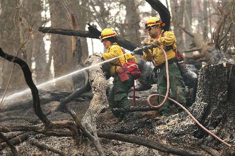 November 15, 2016, Clayton: Firefighters Valerie Lopez and Mark Tabarez, from southeast New Mexico, put out hot spots at the Rock Mountain Fire along Old Coleman River Road on Tuesday, Nov. 15, 2016, near Clayton. Curtis Compton/ccompton@ajc.com