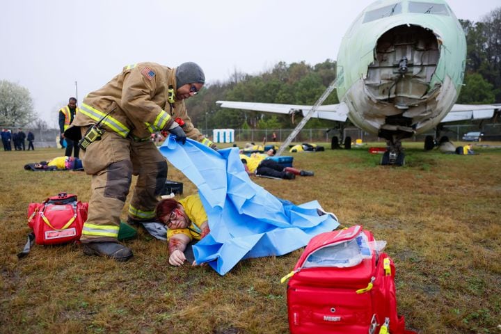 A firefighter covers a fake victim as Hartsfield-Jackson International Airport held a full-scale disaster drill with Atlanta Firefighters, law enforcement, rescue personnel, and nearly 70 volunteers who participated in a triennial exercise known as “Big Bird” on Wednesday, March 6, 2024.
Miguel Martinez /miguel.martinezjimenez@ajc.com