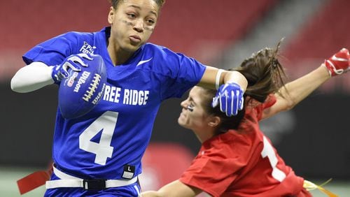 Peachtree Ridge quarterback Monique Thame, left, runs past a North Gwinnett player during the finals of the flag football championship Dec. 20, 2018 at Mercedes-Benz Stadium. The Gwinnett County girls flag football teams are playing exhibition games 4:30 to 6 p.m. Saturday at the Georgia World Congress Center as part of the pre-Super Bowl festivities. ANNIE RICE FOR THE AJC