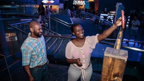 Corry Dupriest (L) and JaNive Johnson play a game of Connect Four during the Sips Under the Sea, Game Night, at Georgia Aquarium in Atlanta last year.  STEVE SCHAEFER / SPECIAL TO THE AJC