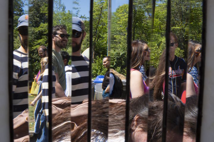 People are seen through an artwork at the Glass Reflections Studio booth during the Dogwood Festival in Piedmont Park on Saturday, April 13, 2024.   (Ben Gray / Ben@BenGray.com)