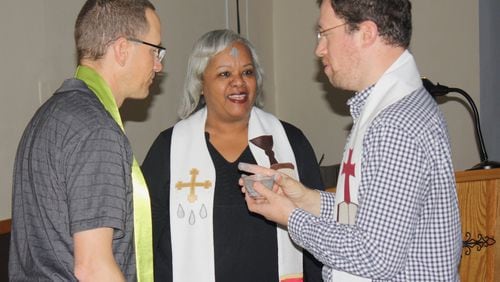 Co-pastors Tim Rodgers, left, and Catherine Gilliard speak with one of the members during an Ash Wednesday service at New Life Covenant Church. Contributed
