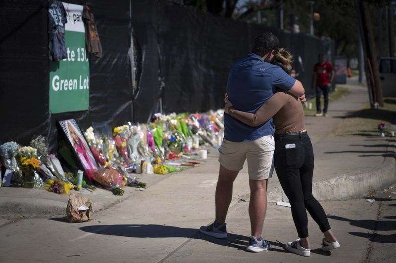 FILE - Two people who knew an unidentified victim of a fatal incident at the Houston Astroworld concert embrace at a memorial on Nov. 7, 2021, in Houston. A judge has declined to dismiss hundreds of lawsuits filed against rap star Travis Scott over his role in the deadly 2021 Astroworld festival in which 10 people were killed in a crowd surge. State District Judge Kristen Hawkins issued a one-page order made public Wednesday, April 24, 2024, denying Scott’s request to be dropped from the case. (AP Photo/Robert Bumsted, File)