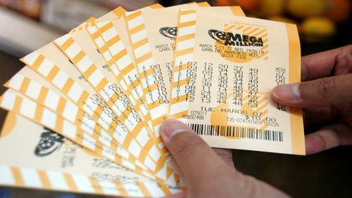 <p>Man holds a bundle of Mega Millions lottery tickets&nbsp;</p>