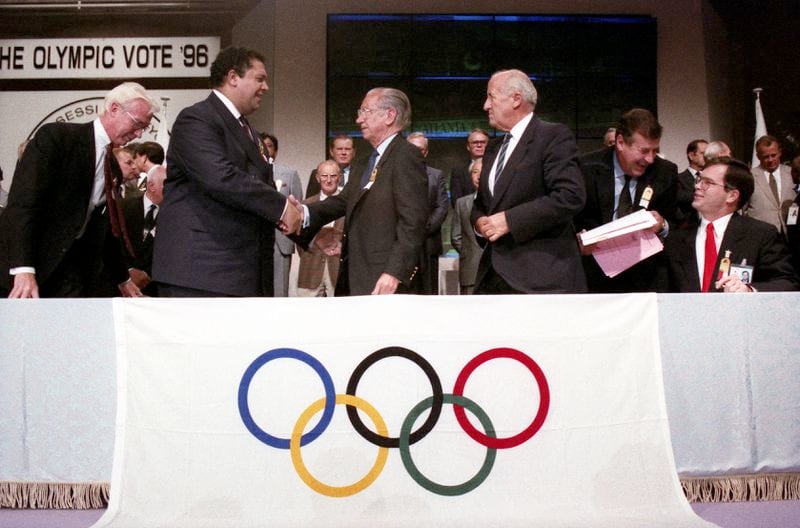 Mayor Maynard Jackson shakes the hand of Juan Samara after winning the Olympic bid, on Sept. 18, 1990. At right is Atlanta Organizing Committee President Billy Payne. AJC File / W.A. Bridges Jr.