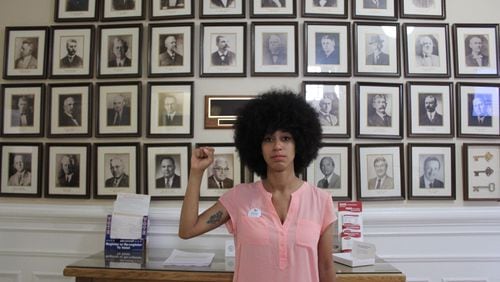 Mariah Parker, a 26-year-old University of Georgia doctoral student and newly elected Athens-Clarke County commissioner, stands before portraits of former elected officials inside Athens City Hall.