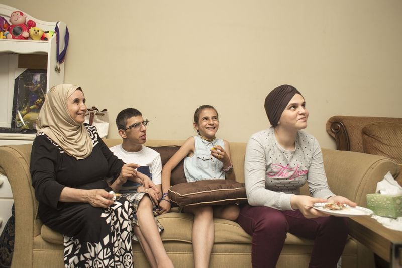 The Youssef family sits together during dinner at their Decatur apartment, sharing stories. Chad Rhym / Chad.Rhym@ajc.com