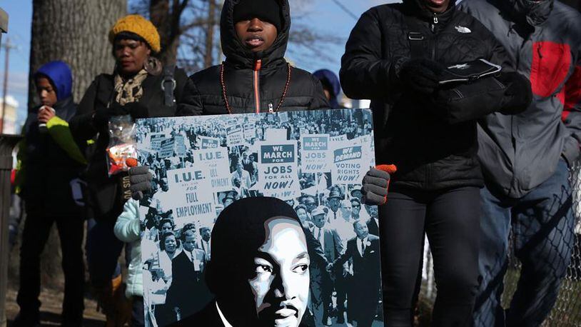 WASHINGTON, DC - JANUARY 18: Eight-year-old local resident Isaiah Williams holds a portrait of Martin Luther King Jr. during the annual Martin Luther King Holiday Peace Walk and Parade January 18, 2016 in Washington, DC. The nation observes the life and legacy of Martin Luther King Jr. today. (Photo by Alex Wong/Getty Images)